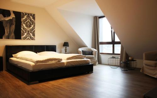 - une chambre avec un lit, une chaise et une fenêtre dans l'établissement Hotel Victoria, à Hövelhof