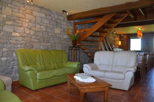 a living room with two chairs and a table at Gîtes Ferme de la Barrière in Chimay