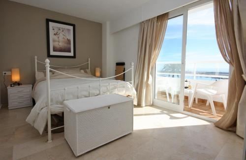 een slaapkamer met een bed en een balkon met uitzicht bij Apartment SUNRISE in Estepona