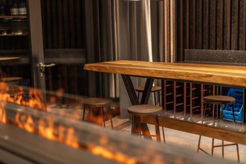 a table and stools in a room with a fire at Macardo Premium B&B in Bissegg