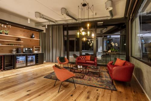 a living room with red chairs and a table at Macardo Premium B&B in Bissegg