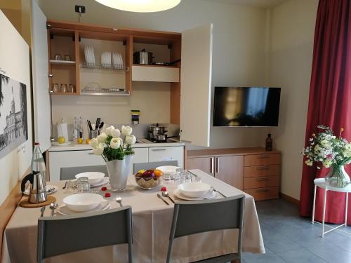 a kitchen with a table with chairs and a television at Hotel Borgo Brianteo in Ponte San Pietro