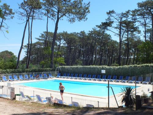 une femme debout en face d'une piscine dans l'établissement Camping de la Dune "Les Flots Bleus", à Pyla-sur-Mer