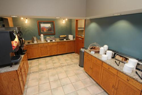 a large kitchen with wooden cabinets and a flat screen tv at Greystone Lodge on the River in Gatlinburg