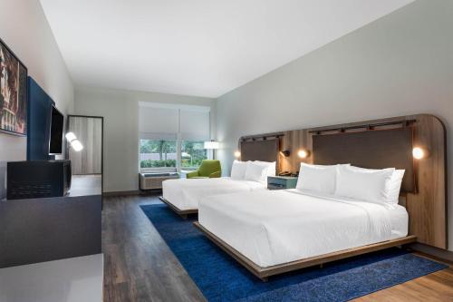 a hotel room with two beds and a television at TRYP by Wyndham Orlando in Orlando