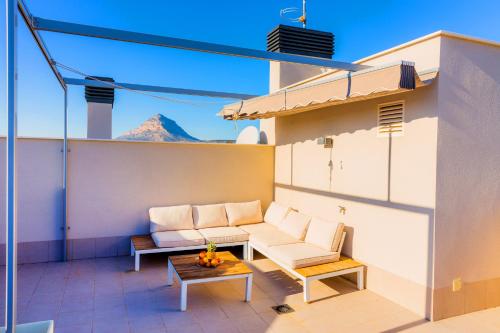 a patio with a couch and a table on a roof at Arenal Dream Penthouse I Javea Arenal by Rock Rentals in Jávea