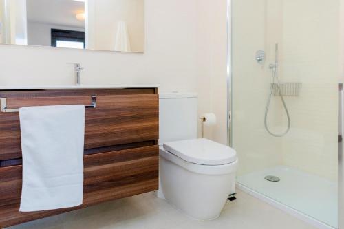 a white bathroom with a toilet and a shower at Arenal Dream Penthouse I Javea Arenal by Rock Rentals in Jávea