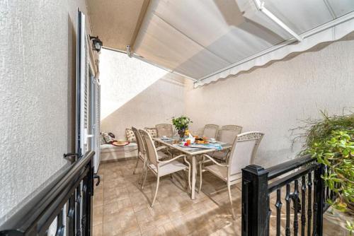 eine Terrasse mit einem Tisch und Stühlen auf dem Balkon in der Unterkunft Ioannas Luxury Apartment in Istron in Kalo Chorio