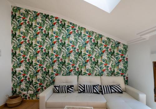 - un salon avec un canapé et un grand papier peint dans l'établissement ATICO CAPRICHOS ARANDA, à Aranda de Duero