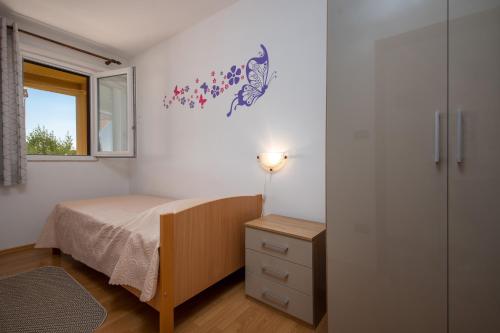 een slaapkamer met een bed, een dressoir en een raam bij IVANA in Vrsar