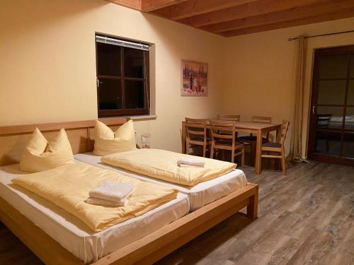 2 Betten in einem Zimmer mit einem Tisch und einem Fenster in der Unterkunft Störitzland Betriebsgesellschaft mbH in Grünheide