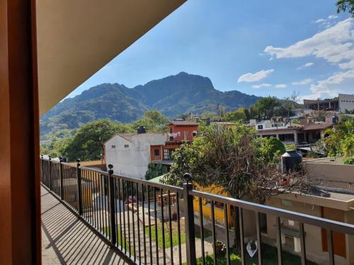 uma varanda com vista para a cidade e para as montanhas em Artesanos 11 by Rotamundos em Tepoztlán