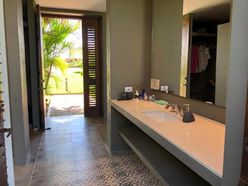 ein Badezimmer mit einem Waschbecken und einem großen Spiegel in der Unterkunft Territorio Magico Dibulla in Dibulla