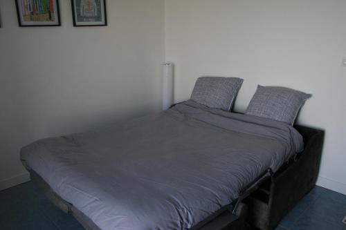 un letto con due cuscini sopra in una camera da letto di escapade en mer a Ault