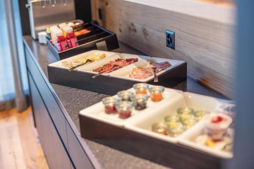 a buffet with several trays of food on a counter at Macardo Premium B&B in Bissegg