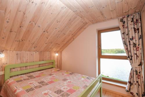 a bedroom with a bed and a window at Vila LATO, Druskininkai in Latežeris