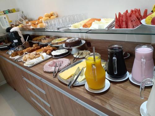 a buffet with a lot of breakfast foods and drinks at Pousada Recanto do Mar in Navegantes