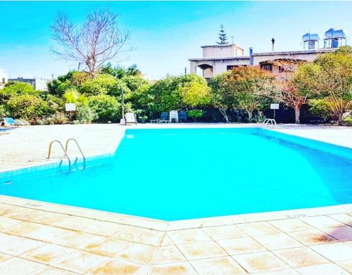 a large blue swimming pool in front of a building at Prima Casa 005 in Paphos City