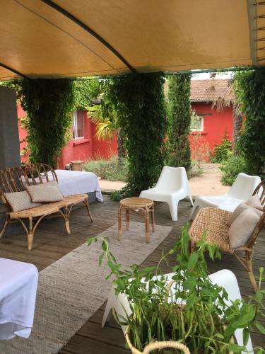 an outdoor patio with chairs and tables and ivy at Logis Hôtel O Lodge in Cleppé