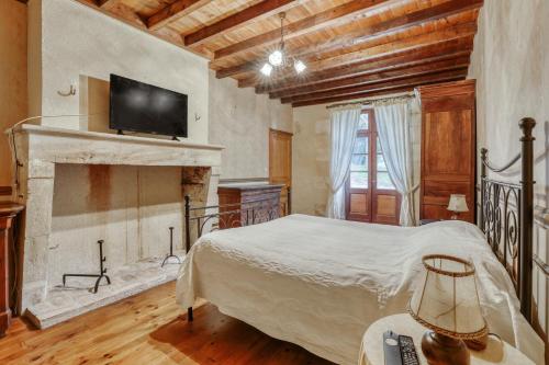 ein Schlafzimmer mit einem Bett und einem Kamin in der Unterkunft Maison de 4 chambres avec jardin clos et wifi a Marcellus in Marcellus
