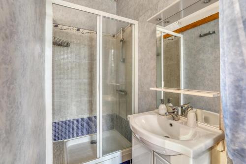 ein weißes Bad mit einem Waschbecken und einer Dusche in der Unterkunft Maison de 4 chambres avec jardin clos et wifi a Marcellus in Marcellus