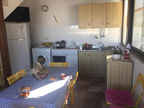a small kitchen with a table with a blue table cloth at Villa nel Salento - Casa Maria e Casa Glory in Porto Cesareo