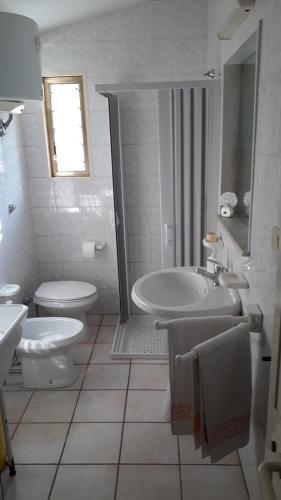 a white bathroom with a sink and a toilet at Villa nel Salento - Casa Maria e Casa Glory in Porto Cesareo