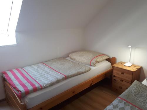 Cama pequeña en habitación con mesita de noche en Urlaub bei Familie Lasch, en Fehmarn