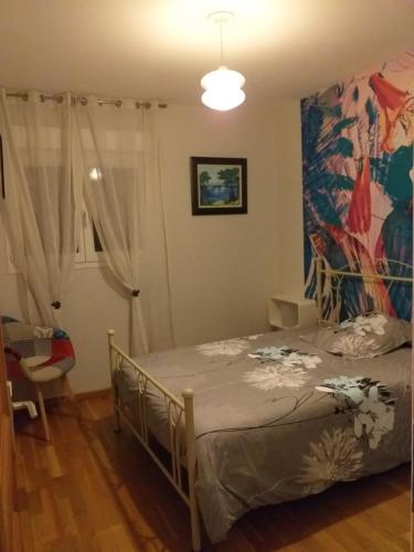 1 dormitorio con 1 cama y una pintura en la pared en Chambres d'Hôtes : chez Mamie Riclaude en Orsan