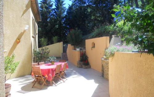 un patio con mesa y sillas en un patio trasero en Chambres d'Hôtes : chez Mamie Riclaude en Orsan