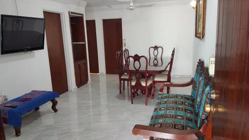 a living room with a table and chairs and a tv at Casa amueblada - Mazatlán in Mazatlán