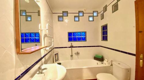 a bathroom with a tub and a sink and a toilet at Country Sun Apartments in Casarabonela