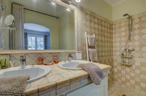 baño con 2 lavabos y espejo grande en La Méridienne, en Mouriès