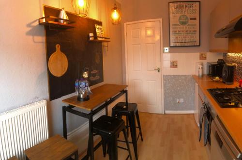 a kitchen with a small table and stools in it at Ann Apartments opposite the Pier with sea view in Portsmouth