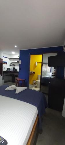 a bedroom with a bed with a blue and yellow wall at Massai Apartments in Playa Flamingo