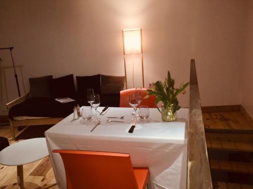 a table with a white table cloth and wine glasses at Logis Hôtel O Lodge in Cleppé