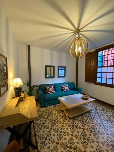 a living room with a blue couch and a table at Old Town House La Laguna in Las Lagunas