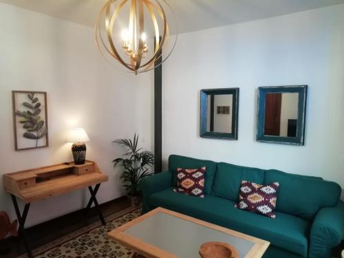 サン・クリストバル・デ・ラ・ラグーナにあるOld Town House La Lagunaのリビングルーム(緑のソファ、テーブル付)