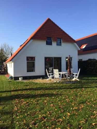 a house with a table and chairs in the yard at Topsleep Villa Lathum in Lathum