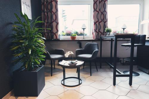 a waiting room with chairs and a table and a plant at La Stella in Süßen