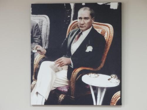 a man in a suit sitting in a chair with a table at Serenti Hotel in Giresun