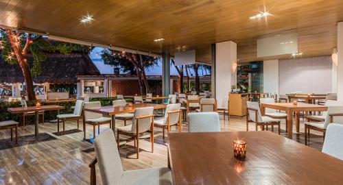 a restaurant with wooden tables and chairs and tables and chairs at Villa Premiere Boutique Hotel & Romantic Getaway - Adults Only in Puerto Vallarta