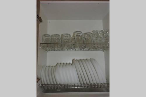 a shelf with a row of glasses in a refrigerator at Buhardilla rústica muy acogedora in Villahermosa del Río