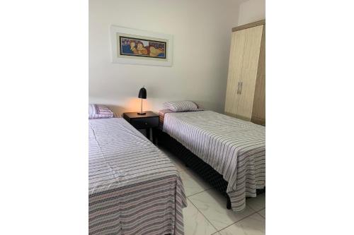 two beds sitting next to each other in a room at Loft Central Master Collection in Passo Fundo