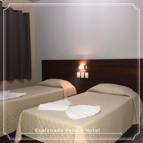 two beds in a hotel room with towels on them at Esplanada Palace Hotel in Barra do Garças
