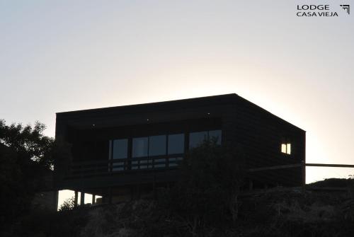 a house on a hill with the sunset in the background at Lodge Casa Vieja in Curanipe