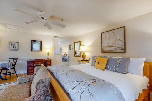 1 dormitorio con 1 cama y ventilador de techo en Brewster by the Sea Inn en Brewster