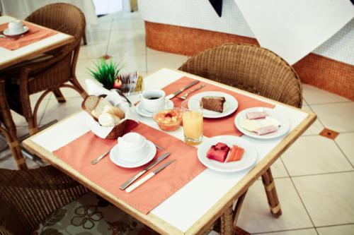 a table with a plate of food on it at Residencial Bella Vista Suites in Sao Paulo