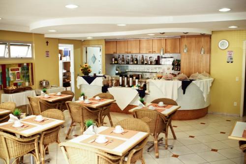 a restaurant with tables and chairs and a counter at Residencial Bella Vista Suites in Sao Paulo