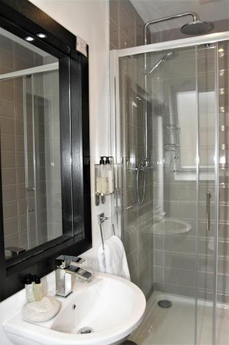 a bathroom with a sink and a glass shower at The Lane - Boutique Residence in Galway